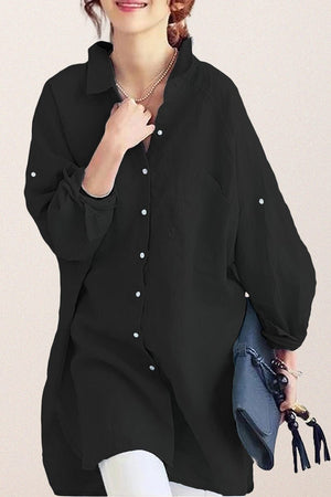 Black oversized linen shirt with relaxed fit and button details worn by woman holding blue handbag