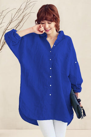 Woman wearing oversized linen shirt in vibrant blue with relaxed fit and button-down front