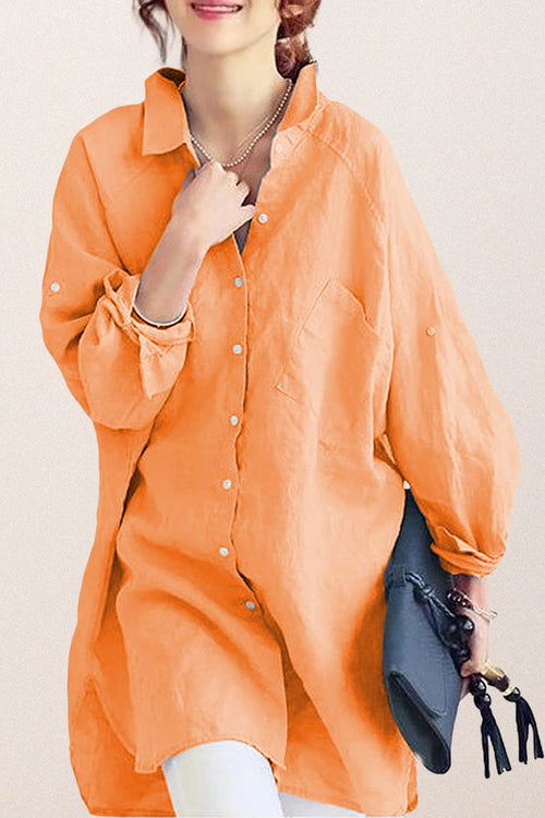 Oversized linen shirt in soft orange with relaxed fit and button front, styled casually with accessories.