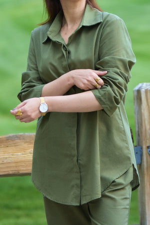 Oversized 100% cotton shirt in olive green with rolled-up sleeves and matching pants set outdoors