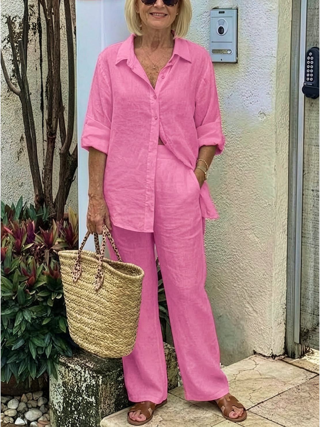 Woman wearing oversized 100% cotton pink shirt and wide-leg pants co-ord set with woven handbag and sandals outdoors