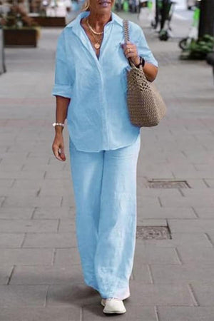 Woman wearing oversized 100% cotton light blue shirt and wide-leg pants co-ord set walking outdoors