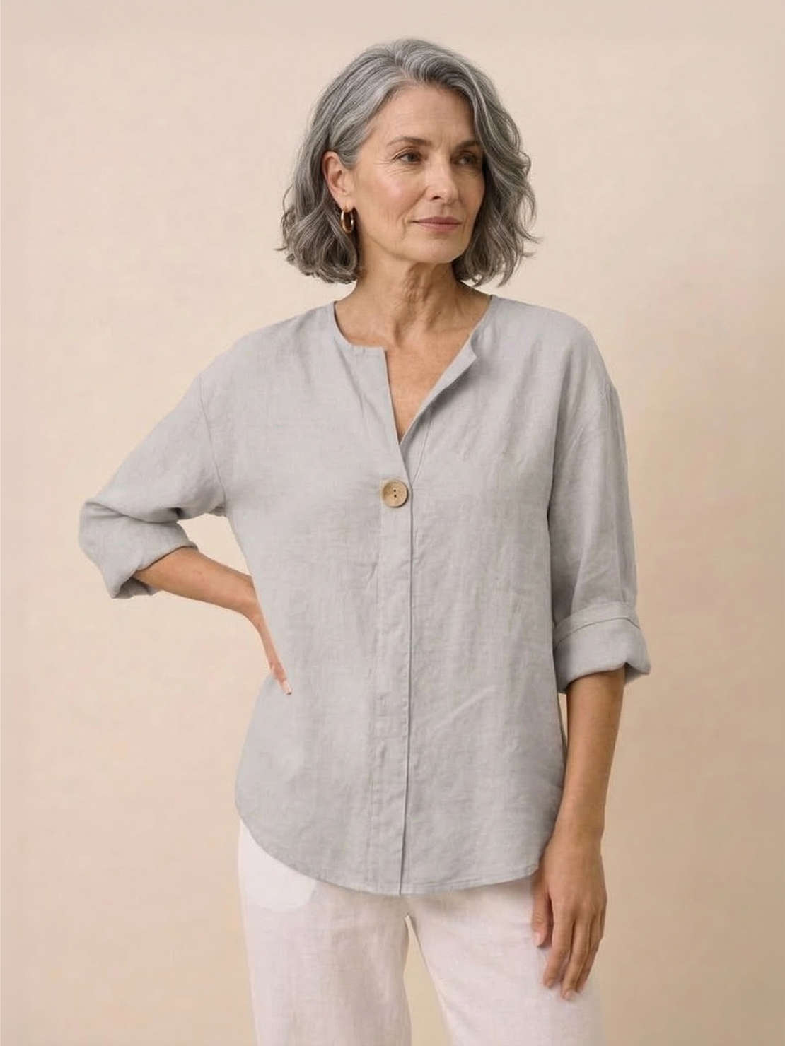 White pure linen age-defying shirt with elegant button detail hanging on wooden hanger