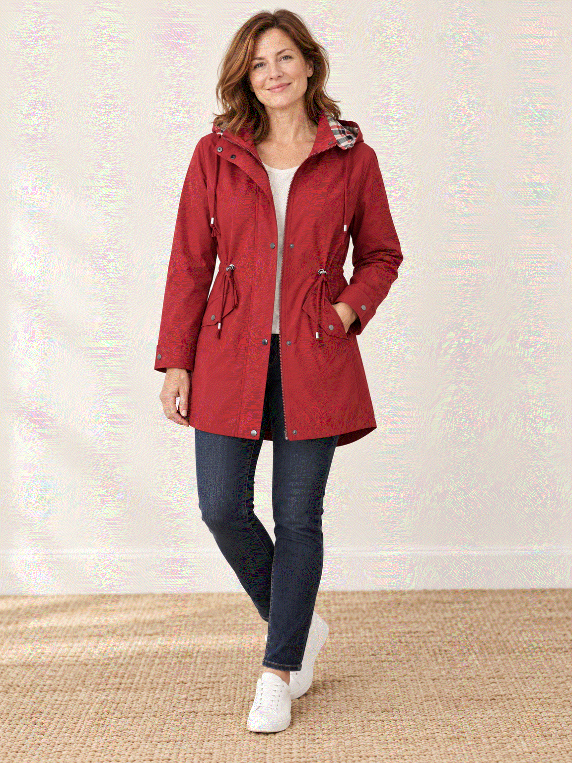 woman wearing plaid-lined hooded rain jacket with snap flap pockets and drawstring waist outdoors