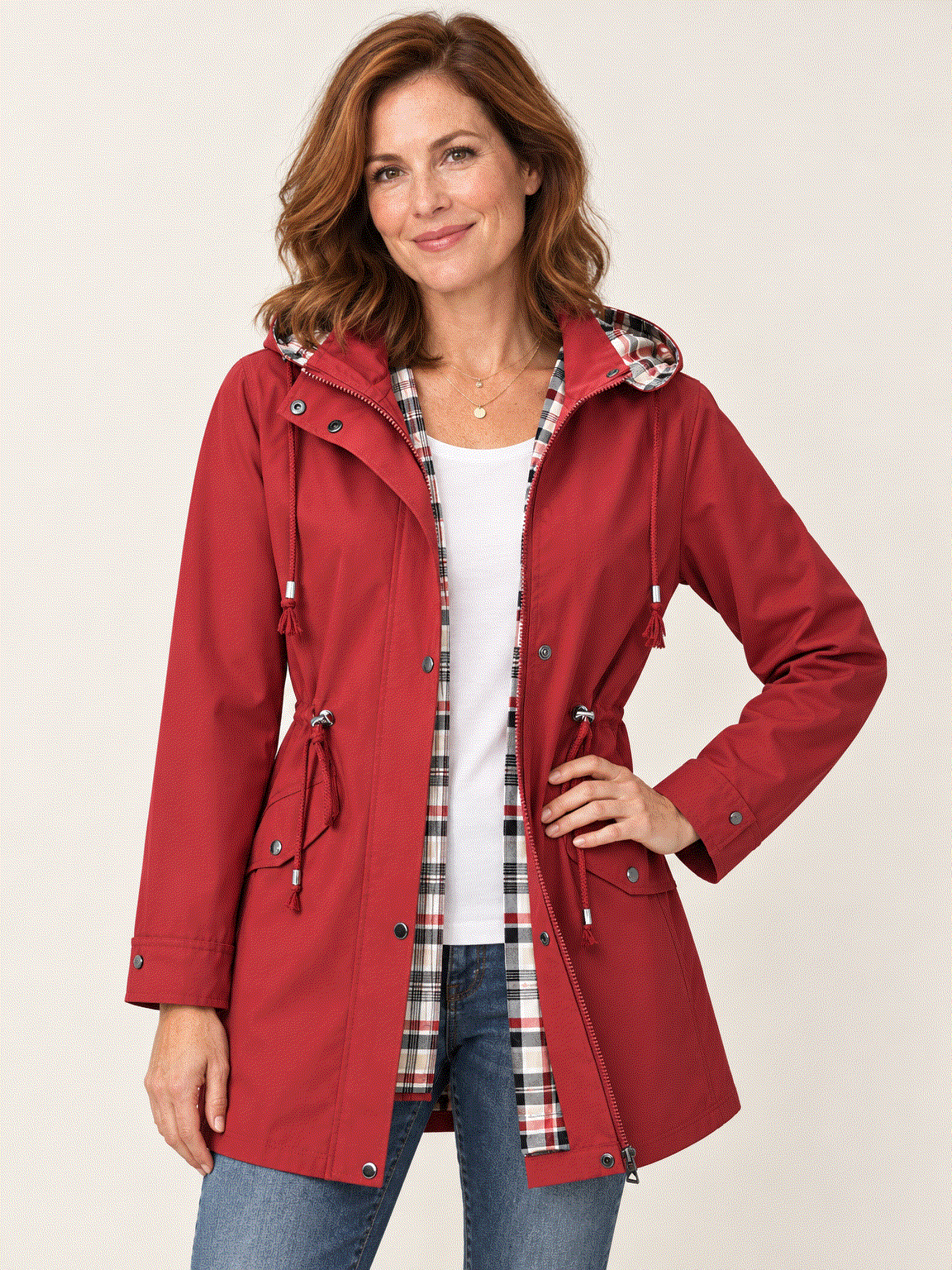 woman wearing red plaid-lined hooded rain jacket with snap pockets and drawstring waist