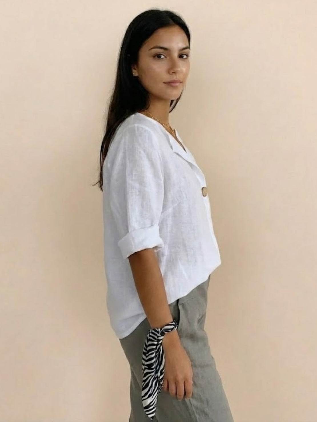 White pure linen age-defying shirt with elegant button detail on wooden hanger