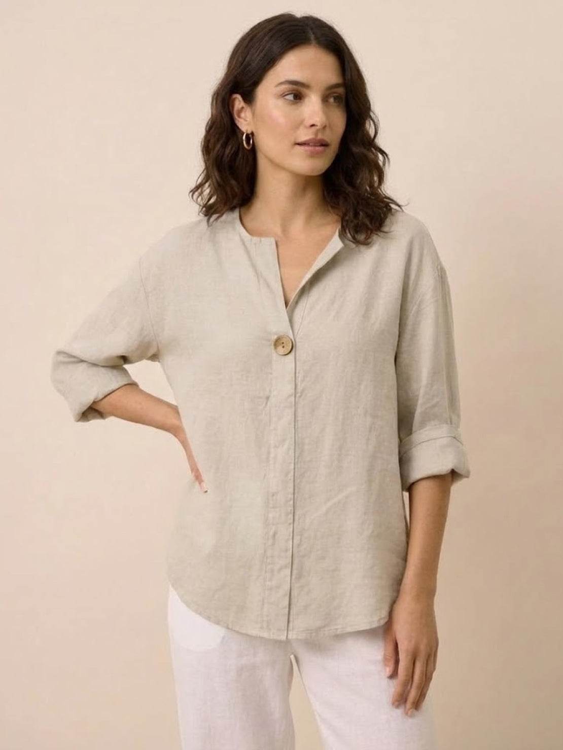 White pure linen age-defying shirt with elegant button detail on hanger against white background