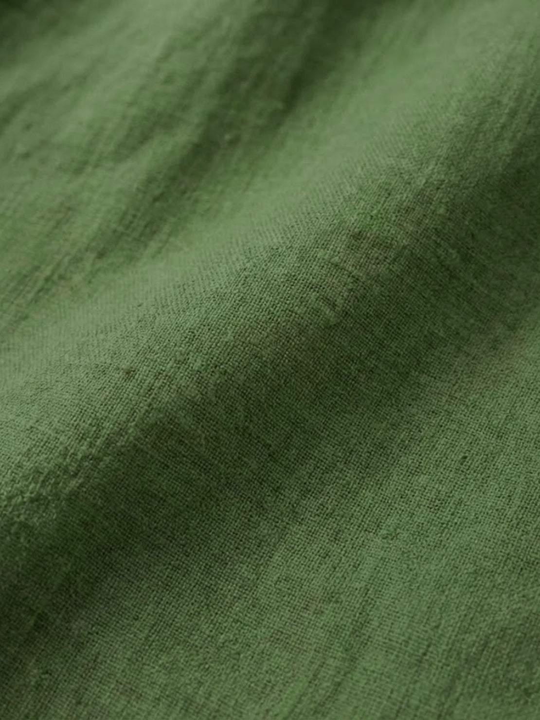 White pure linen age-defying shirt with button detail on hanger against white background