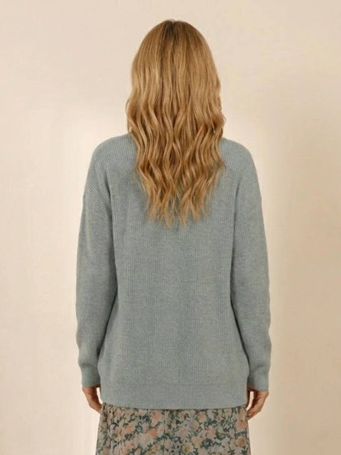 Relaxed fit oversized knitwear cardigan in light blue rear view on model with wavy blonde hair