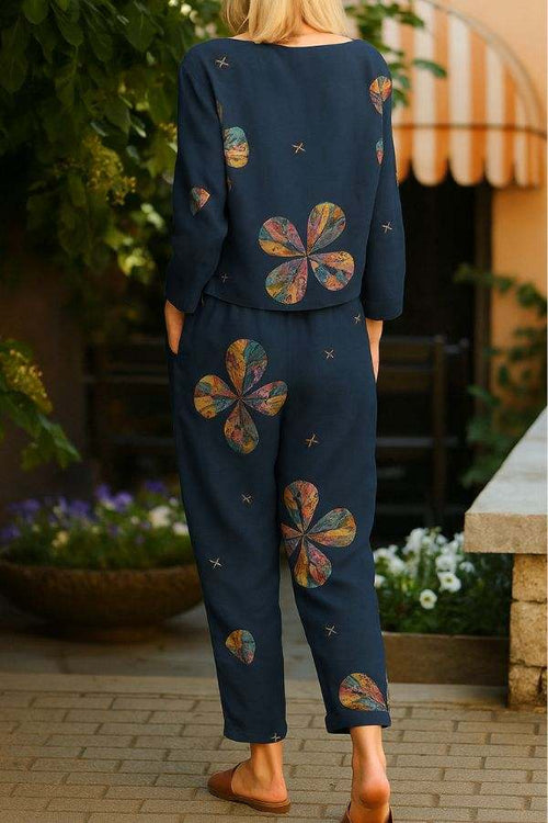 Woman wearing a retro patterned linen two-piece set with floral designs in navy blue outdoors