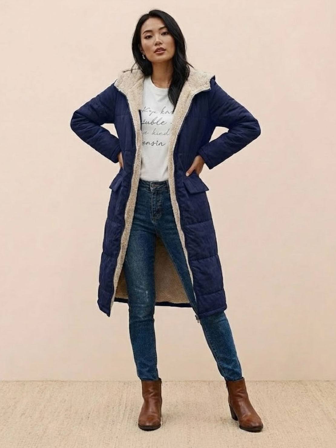 Woman wearing navy Sherpa-lined hooded teddy coat with cozy sherpa interior and long silhouette outdoors