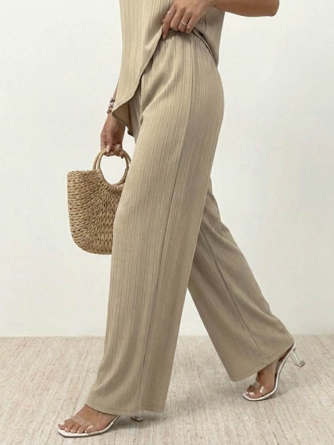 Woman wearing Textured Elegance two-piece set with asymmetrical top and wide-leg pants