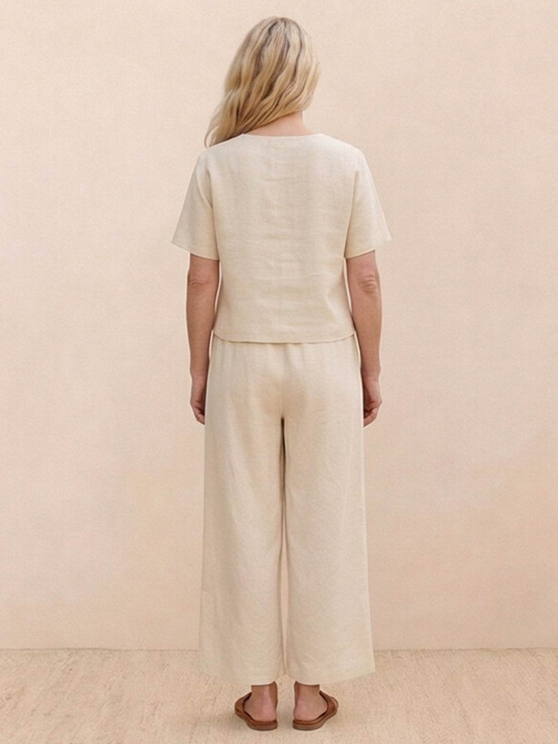 Woman wearing a relaxed loose fit co-ord set with soft-tailored top and wide-leg bottoms in solid color