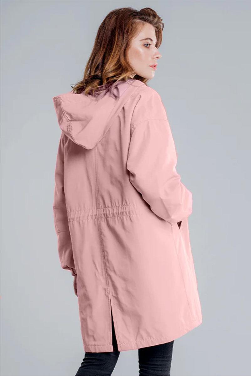 Woman wearing pink oversized Rain Couture Windbreaker windproof water-resistant jacket with hood and back slit