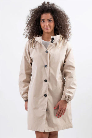 Woman wearing beige Rain Couture Windbreaker oversized water-resistant jacket with hood and button closure