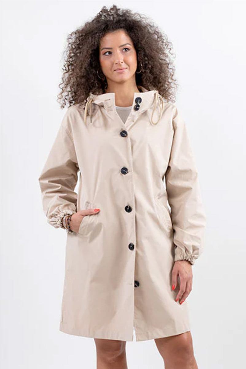 woman wearing beige oversized Rain Couture Windbreaker jacket with hood and button closure