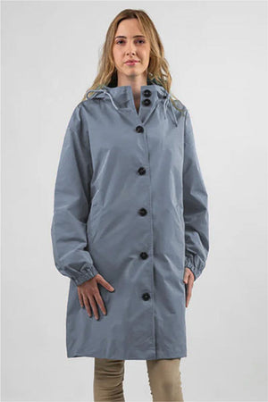 Woman wearing oversized blue Rain Couture Windbreaker water-resistant jacket with hood and button closure
