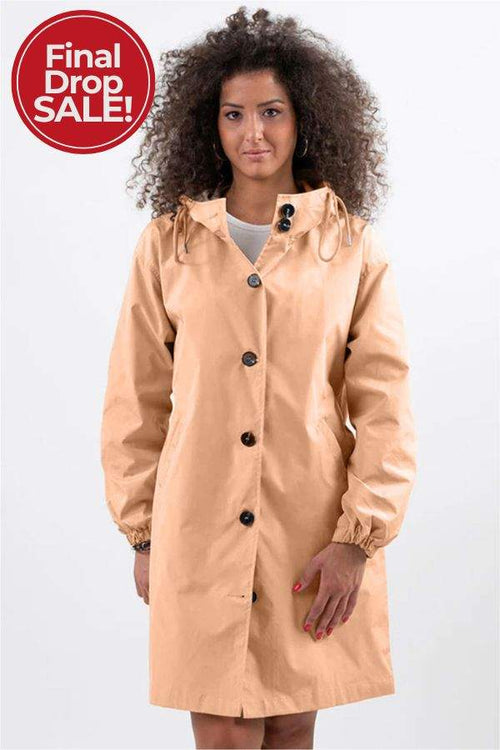woman wearing beige oversized Rain Couture Windbreaker jacket with hood and button details