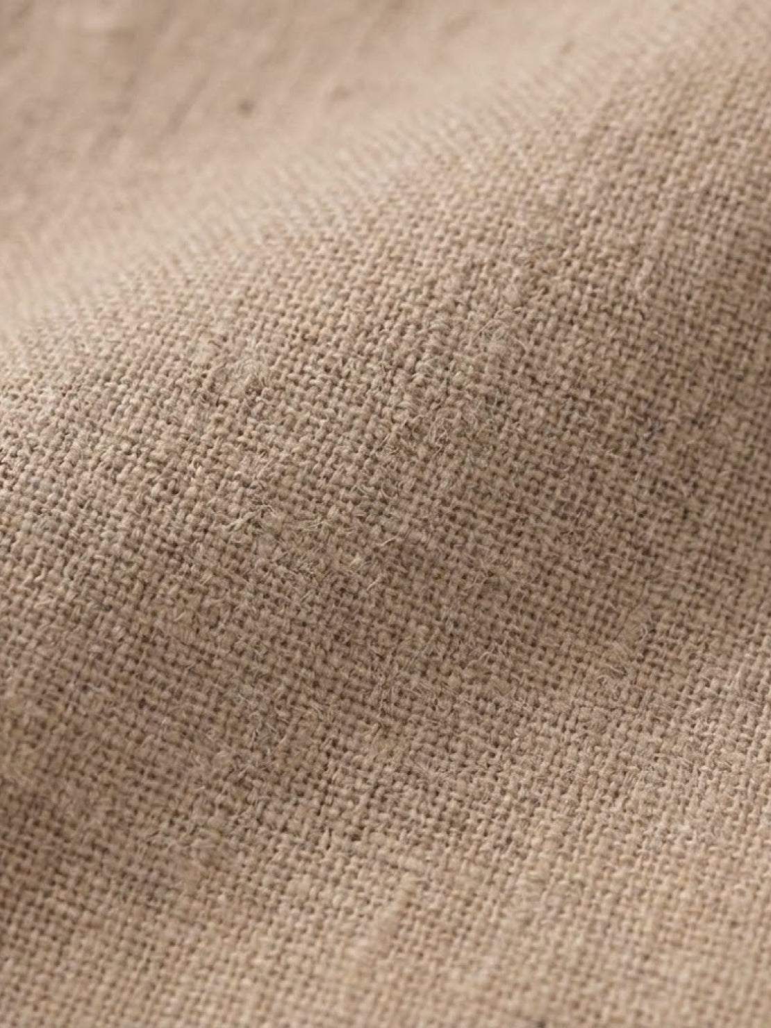 Close-up of beige lightweight cotton fabric texture for cotton dress