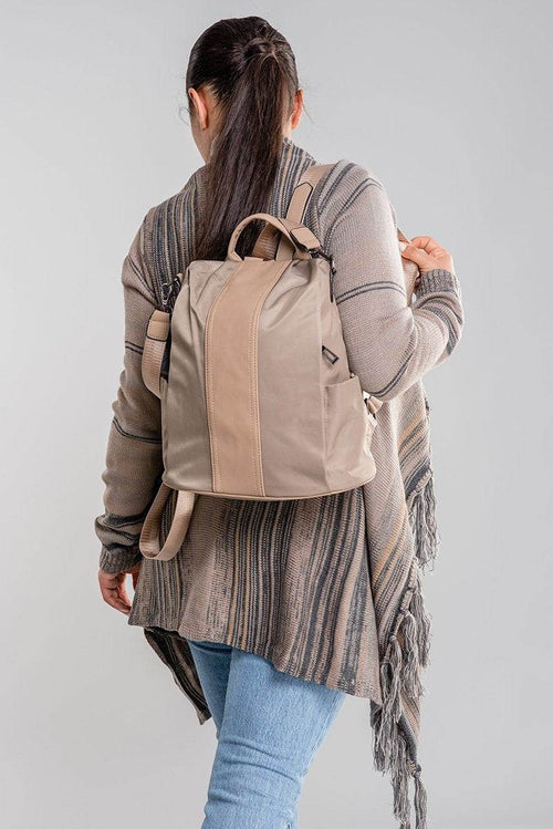 Woman wearing beige anti theft waterproof fashion backpack with adjustable straps and multiple compartments