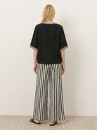 Woman wearing striped wide-leg co-ord set with oversized top and palazzo pants