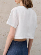 Lightweight 100% linen French top with V-neck, three-button front, short sleeves, and relaxed boxy shape in light khaki and off white
