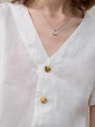 Lightweight 100% linen French top with V-neck, short sleeves, three-button detail, and relaxed boxy cropped hem in light khaki and off white colors