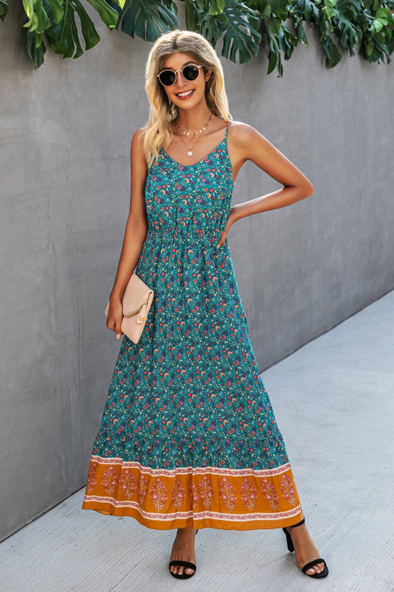 Woman wearing a vintage flower prints maxi dress with spaghetti straps and elastic waist, standing outdoors with sunglasses and a clutch.