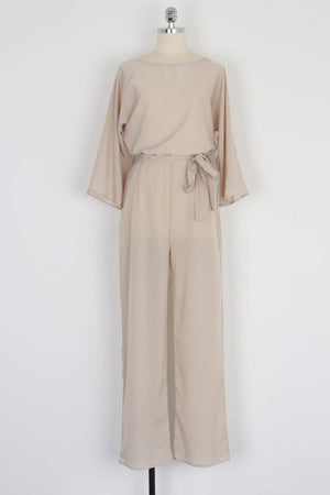 Beige casual long sleeve belted jumpsuit with batwing sleeves and round neck on mannequin