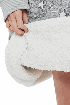 Close-up of ultra-soft white sherpa lining on Lazy Fleece Blanket Sweater with grey fleece exterior and star pattern
