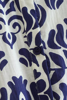 Close-up of blue floral lantern sleeves pattern with button on white polyester fabric