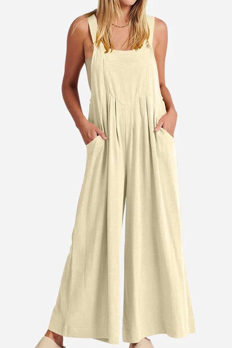 Woman wearing beige Free-Flow Wide Leg Overalls with pockets and adjustable straps.