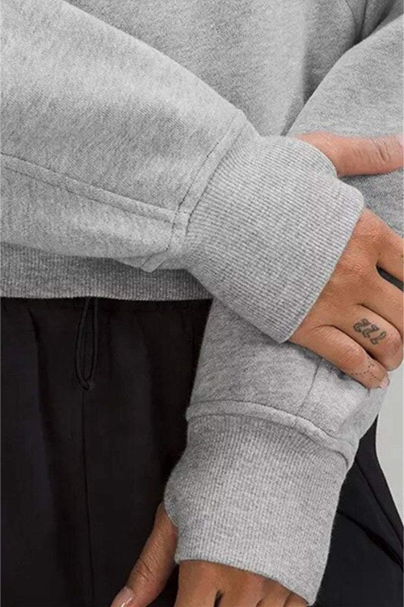 Close-up of gray Cozy Oversized Half-Zip fleece pullover sleeve and cuff on model's arm