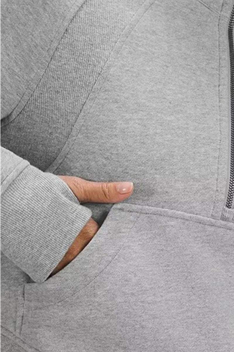 Close-up of cozy oversized half-zip fleece pullover sweatshirt pocket and cuff in light gray fabric