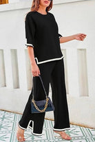 Black short sleeved relaxed fit lounge two-piece set with white trim and wide-leg palazzo pants.