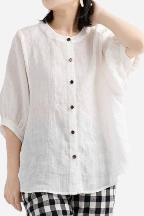 Relaxed loose breathable linen blouse in white with button-down front and rolled sleeves.