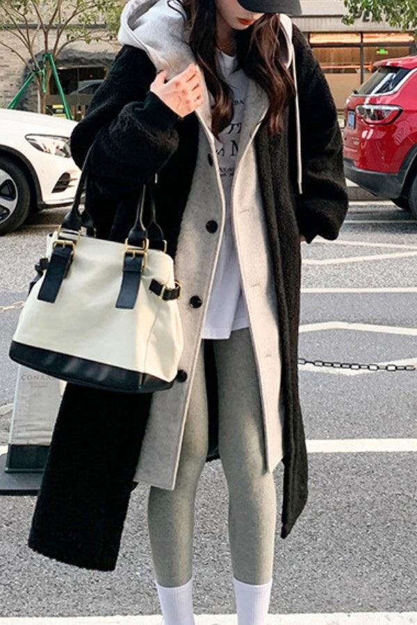 Woman wearing everyday wear oversized sherpa long coat with cozy lining and casual outfit carrying a white and black handbag outdoors