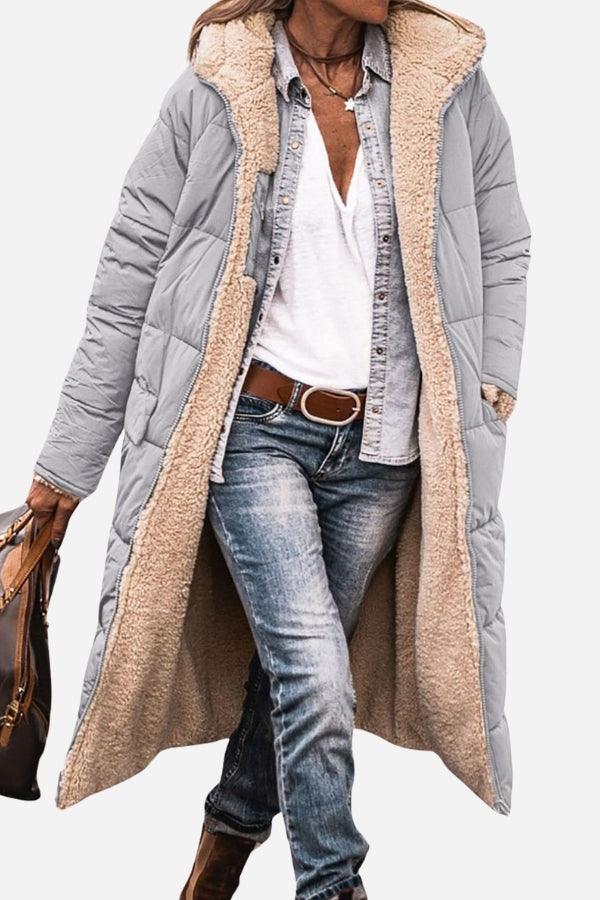 Long Sherpa-lined hooded teddy coat with quilted gray exterior and cozy beige sherpa interior, styled with casual denim and accessories.