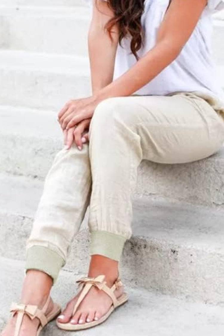 Woman wearing relaxed chic elastic ankles pants sitting on stairs in casual outfit