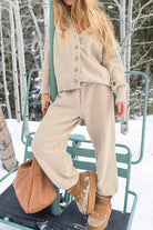 woman wearing beige two-piece knitwear set with relaxed fit standing outdoors in snowy setting