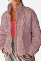 Lightweight puffer travel jacket in mauve color worn with casual outfit, warm and packable design