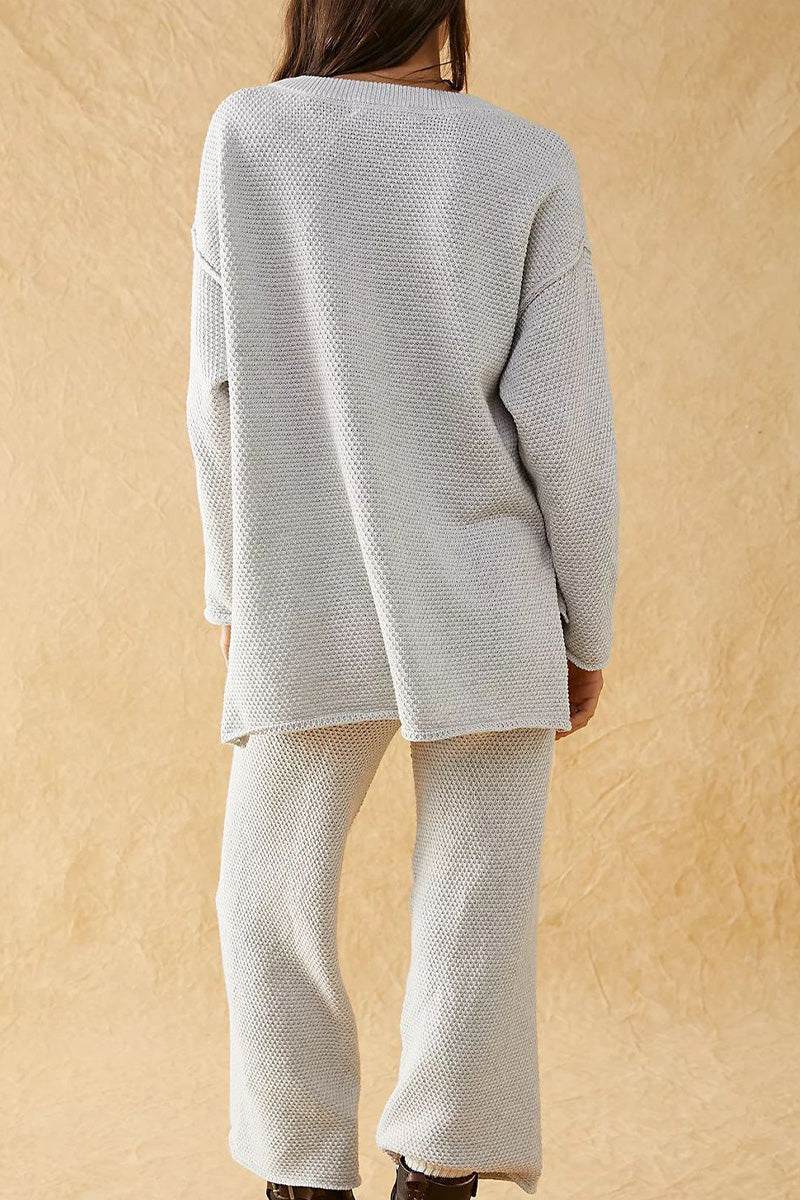 Woman wearing light grey textured two-piece oversized set for multi-weather comfort, featuring long sleeves and wide pants.