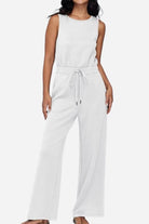 woman wearing white sleeveless wide leg pants jumpsuit with drawstring waist