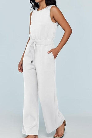 Woman wearing white sleeveless wide leg pants jumpsuit with drawstring waist and pockets