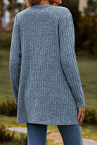 Back view of a woman wearing a long, lightweight, ultra soft knit-like gray cardigan outdoors