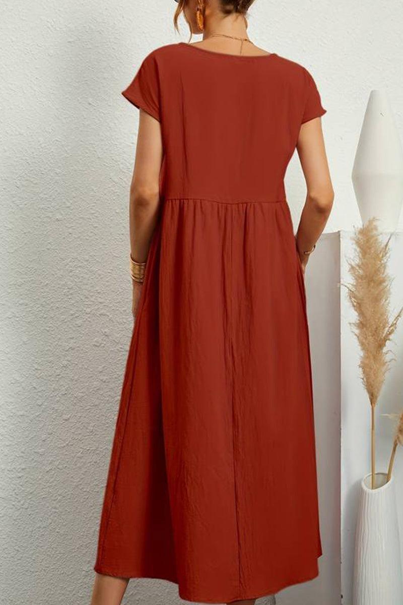 Back view of capped-sleeve voluminous pleated midi dress in rust color on model