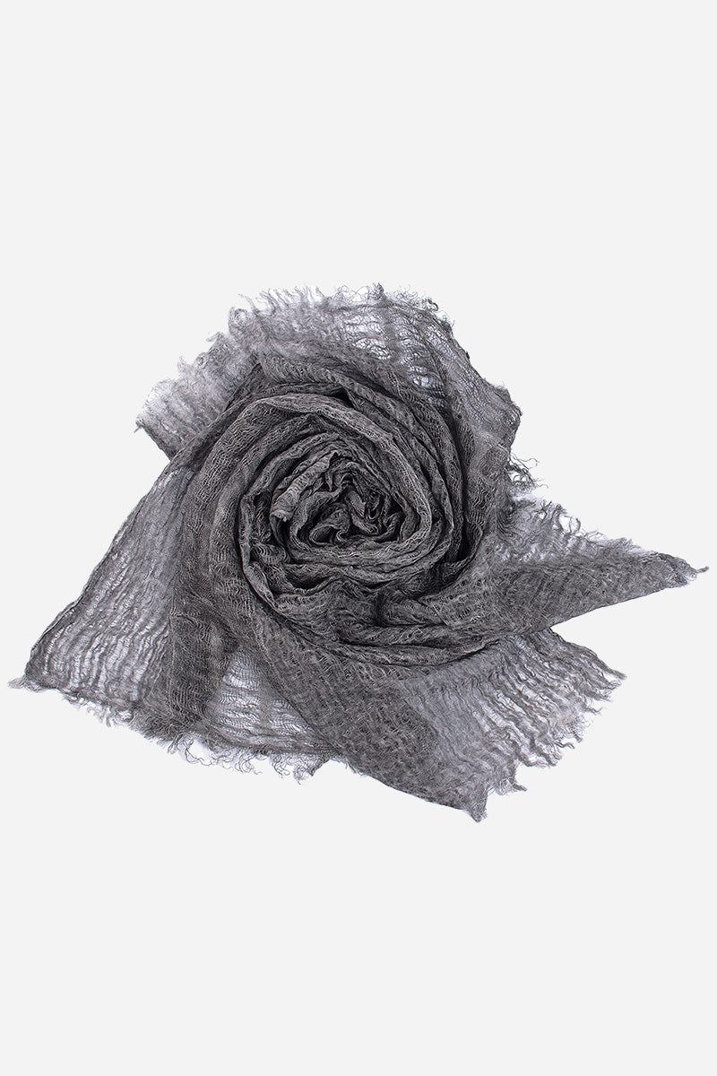 Gray lightweight linen scarf with frayed edges rolled in a spiral on white background