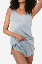 Woman wearing light blue Mulberry silk tank and shorts set lounging comfortably