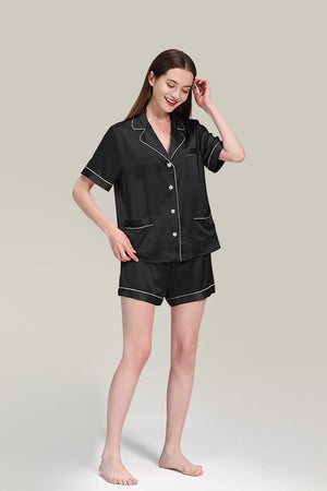 Woman wearing black Mulberry silk buttoned short sleepwear set with white piping