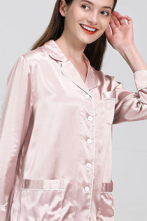 Woman wearing light pink long sleeve silk pajamas with button-up top and pocket detail